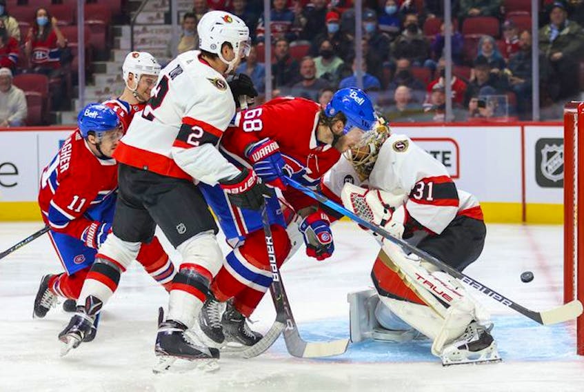 Montreal Canadiens' Brendan Gallagher, left, shoots the puck past Ottawa Senators goalie Anton Forsberg as Habs' Mike Hoffman provides a screen behind Senators' Artem Zub during first period of National Hockey League game in Montreal Tuesday, April 5, 2022. 