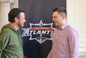 Matthew Hayson, left, one of the owners of The Church Brewing Company, speaks with Saskatchewan Roughriders kicker Brett Lauther March 31 following a meeting with business representatives about a Touchdown Atlantic game coming to Acadia University in July.