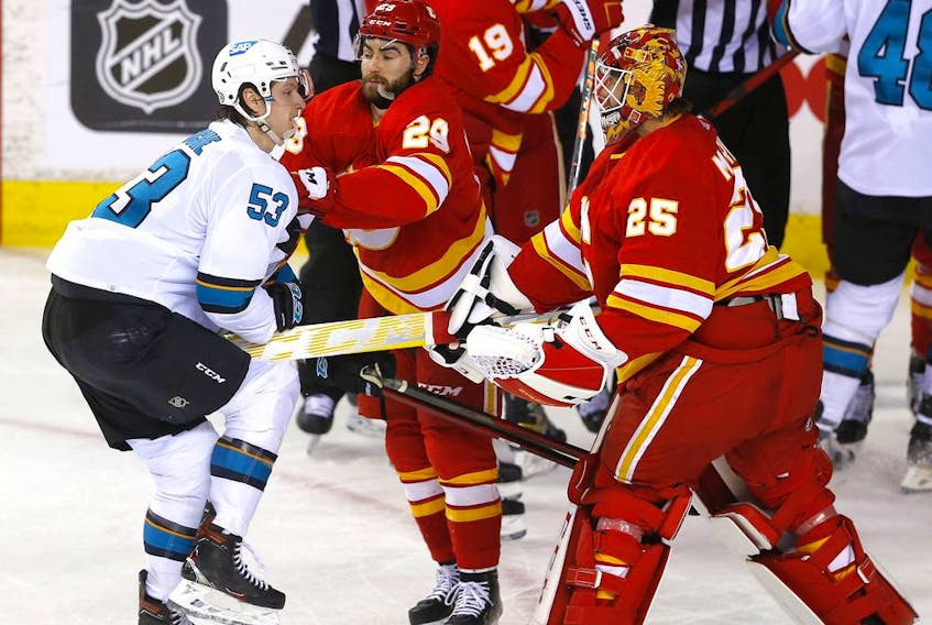 Calgary Flames goalie Jacob Markstrom battles San Jose Sharks defenceman Nicolas Meloche at the Scotiabank Saddledome in Calgary on March 22, 2022. 