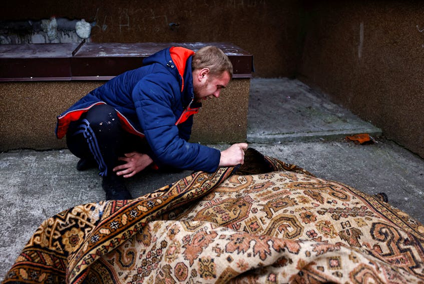 A man pays respects to a labourer killed on the street in Bucha, Ukraine. — Reuters file photo