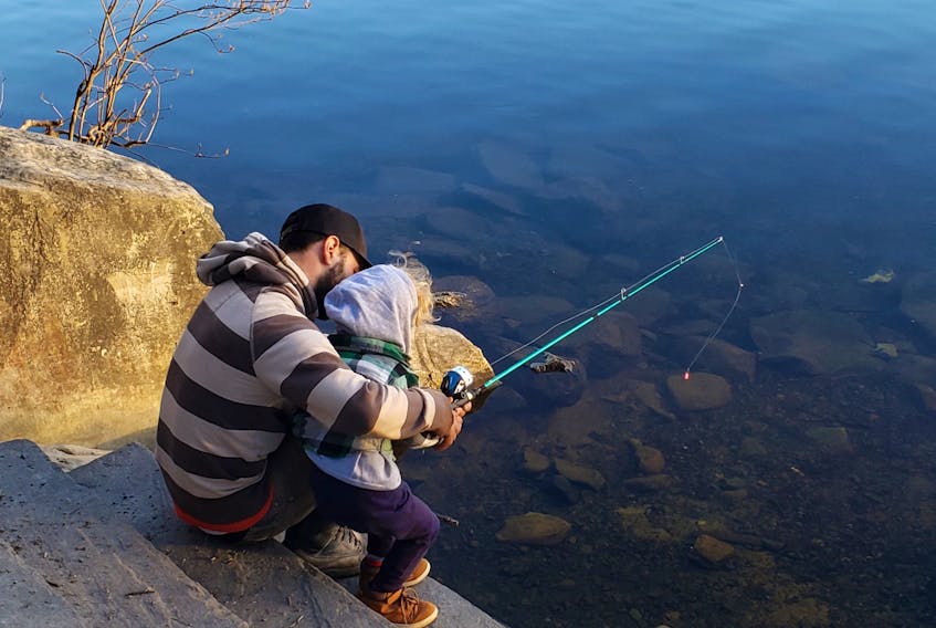 Vincent tries his luck at fishing with his father Anthony. KATY JEAN