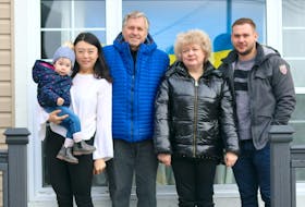 Daniil Titov, far right, stands with his family — daughter Alice, from left, wife Kalie Wang, from left, and parents Sergey and Natlia Titov — on the deck of his home in Westmount on Thursday. Natlia Titov said she's "trying to feel what it’s like to be at peace again" since fleeing their home outside Kyiv, Ukraine. Contributed