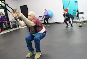 Rex Wright on the TRX with instructor Jennifer McNutt, Patricia Shaw on the ball and Cindy Hann with weights in the background. 
