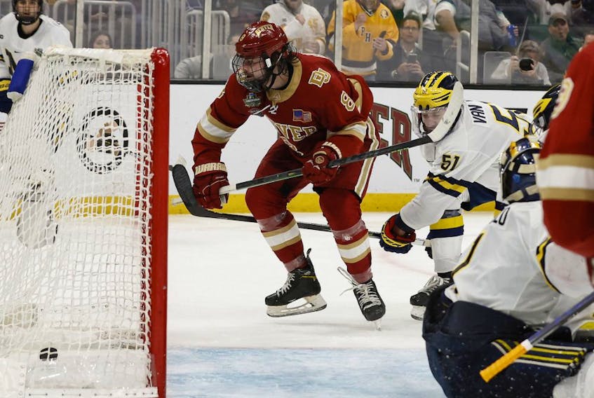 Denver forward Carter Savoie (8) scores the game winning goal during overtime of their 3-2 win over Michigan in the 2022 Frozen Four college ice hockey national semifinals at TD Garden on April 7, 2022. 