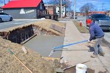 Seward Slade of Sla-Mac Construction made sure everything was smooth and even Friday as he worked on one of two cement bases that will become Sydney’s newest bus shelter on George Street. CAPE BRETON POST PHOTO