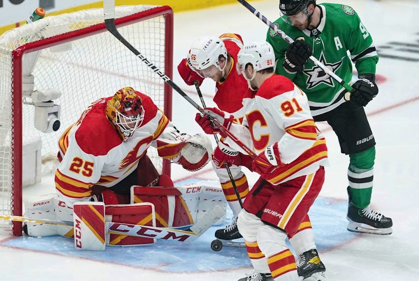  Calgary Flames goaltender Jacob Markstrom reaches to knock the puck away in front of defenceman Noah Hanifin, forward Calle Jarnkrok (91) and Dallas Stars forward Tyler Seguin during Game 4 of their first-round playoff series at American Airlines Center in Dallas on Monday, May 9, 2022.