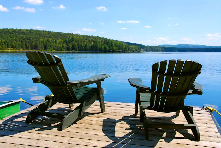 Adirondack chairs beckon by the water at the cottage.