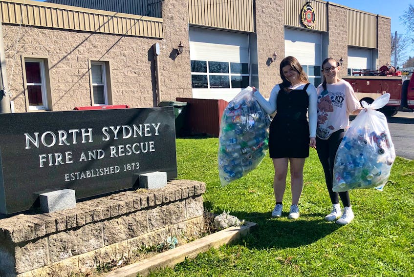 Kayla Clarke, left, and Erin Williams want your refundable bottles. The members of the environment club at Memorial High School are helping at a bottle drive on Saturday at the North Sydney Volunteer Fire Department. Running from 10 a.m. to 4 p.m., the environment club has partnered with the school's interact club and the money raised will be split equally. Clarke and Williams said the environment club intends to use their half to fund community cleanups, including one in June they hope will involve the whole student body. NICOLE SULLIVAN/CAPE BRETON POST