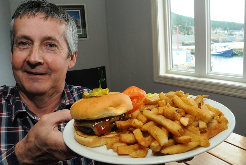 Seafood consultant Bob Hardy shows off the seal burger platter he helped prepare today to serve to lunch lunch guests at a St. John's area restaurant. Joe Gibbons/The Telegram