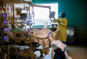 A nurse performs a wellness check of a COVID-19 patient inside the intensive care unit of Humber River Hospital in Toronto, April 15, 2021. 