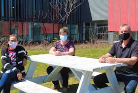 From left, Grade 1 teacher Ann Peck, early literacy and resource teacher Corinne Phillips, and Wagmatcook Chief Norman Bernard sit outside Wagmatcookewey School on Thursday. The teachers were preparing packages for their students, who are all doing at-home learning until May 23 due to a spike in COVID-19 cases in the community. ARDELLE REYNOLDS/CAPE BRETON POST