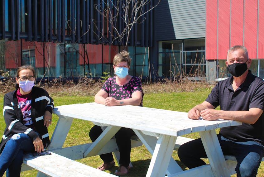 From left, Grade 1 teacher Ann Peck, early literacy and resource teacher Corinne Phillips, and Wagmatcook Chief Norman Bernard sit outside Wagmatcookewey School on Thursday. The teachers were preparing packages for their students, who are all doing at-home learning until May 23 due to a spike in COVID-19 cases in the community. ARDELLE REYNOLDS/CAPE BRETON POST