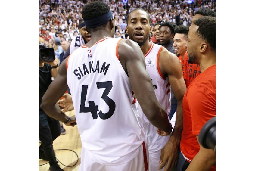 Toronto Raptors Kawhi Leonard SF (2) is congratulated by his teammate Pascal Siakim after the game in Toronto, Ont. on Sunday, May 12, 2019