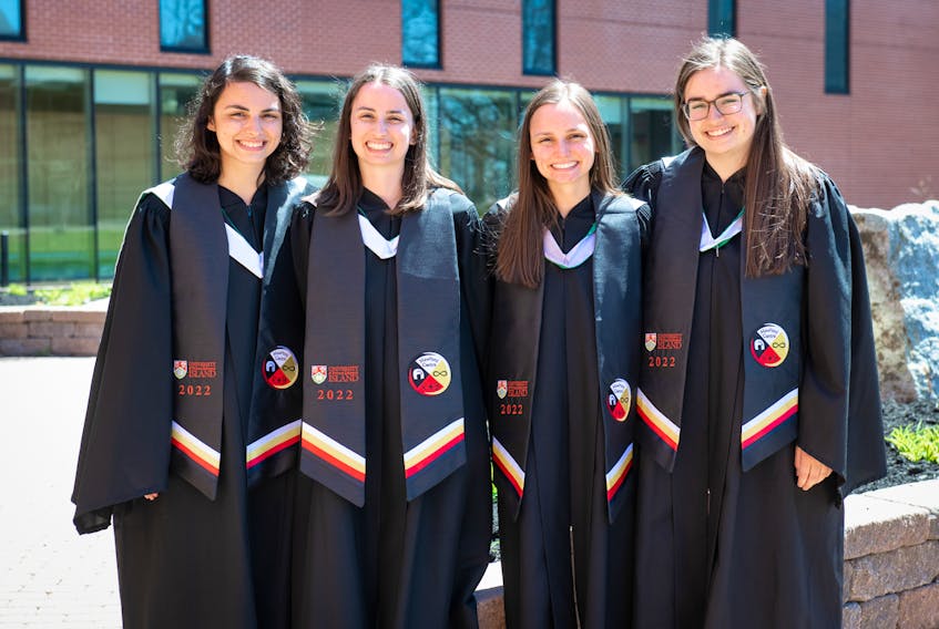 Sisters Julia, Tiffany, Megan and Madison Grounds, from Prince George, BC., celebrate their graduation at the convocation ceremony for the faculties of arts, education and graduate studies on May 12. The sisters are wearing stoles presented to Indigenous graduates on Monday, May 10, as a visual symbol of accomplishment and pride in their heritage. The double curve represents the Mi'kma'ki First Nations, the infinity symbol represents the Métis Peoples, and the polar bear represents the Inuit while the crest on the stole features the four sacred colours: white, yellow, black, and red.