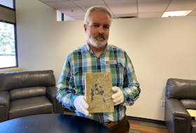 Simon Lloyd holds up a copy of Lucy Maud Montgomery’s 1926 novel The Blue Castle. Andrew Stetson • Special to The Guardian