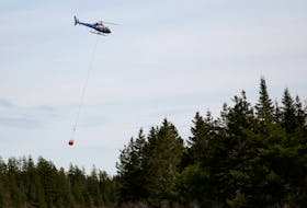 FOR NEWS STORY:
A Department of Natural Resources helicopter leaves with a bucket of water pulled from Millpond, while battling wildfire near Dean, NS Friday May 13, 2022.

TIM KROCHAK PHOTO