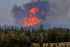 FOR NEWS STORY:
Backdropped by a wildfire, Halifax regional firefighters, provincial Natural Resources crews  battle a large forest fire in Chaplin near Upper Musquodoboit. Friday May 13, 2022.

TIM KROCHAK PHOTO