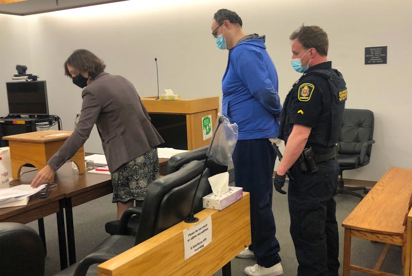Matthew Twyne (centre) reviews a document with defence lawyer Catherine Boyde after he was denied bail in provincial court in St. John's Friday.