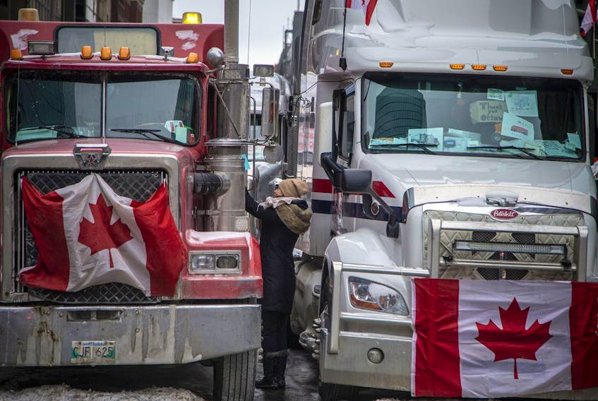 FILE PHOTO: A woman greets a truck driver while vehicles line streets in Centretown during the "Freedom Convoy."