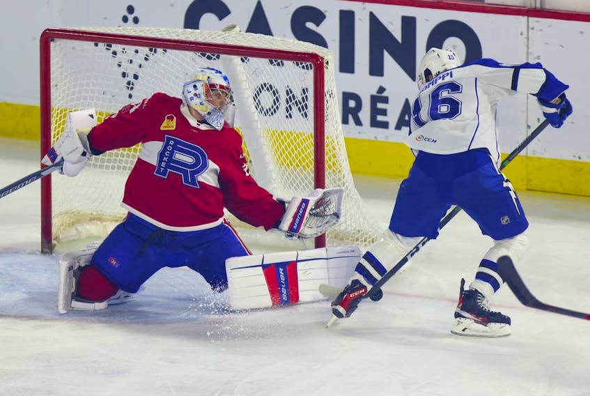 Laval Rocket goalie Cayden Primeau stretches across his crease to make a save on Syracuse Crunch's Otto Somppi during  first period of Game 4 at the Place Bell Sports Complex in Laval on May 14, 2022.