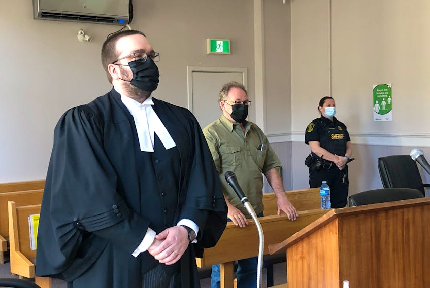 Robert Layman (centre) stands behind his lawyer, Robert Hoskins, as Justice Vikas Khaladkar (not pictured) enters the courtroom at the start of Layman's trial at Newfoundland and Labrador Supreme Court in St. John's May 9.