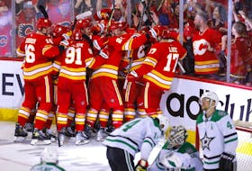 The Calgary Flames celebrate after Johnny Gaudreau scored the overtime winner to defeat the Dallas Stars in the deciding Game 7 of their first-round playoff series at Scotiabank Saddledome in Calgary on Sunday, May 15, 2022. 