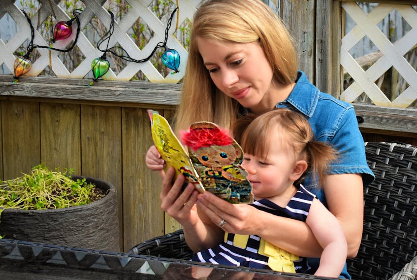Desiree Anstey reads a vintage book to her daughter, Alice. Contributed/Desiree Anstey