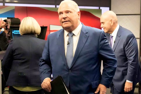 With NDP leader Andrea Horwath and Liberal leader Steven Del Duca behind him, Ontario PC leader Doug Ford departs the Ontario party leaders' debate in Toronto, May 16, 2022.