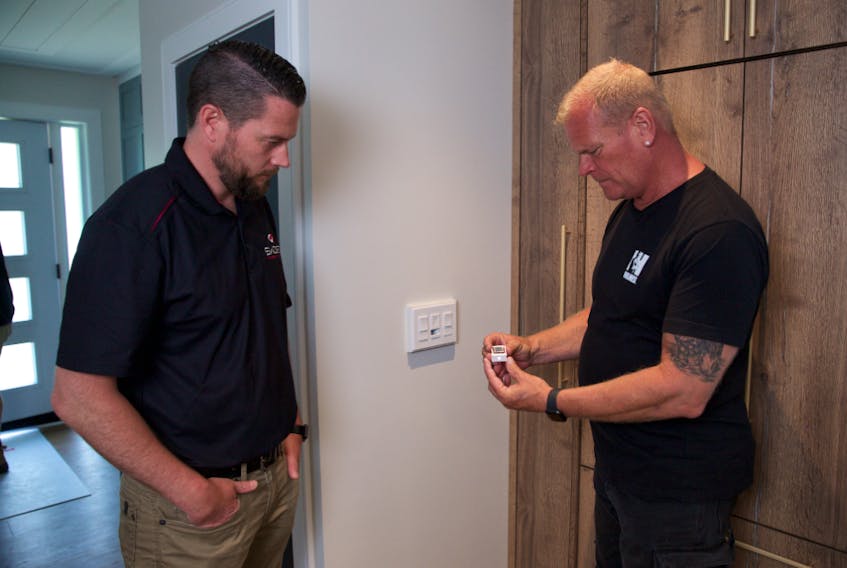Mike Holmes discusses Swidget smart switches with Chris Adamson, on Holmes Family Rescue. 