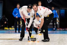 Canada's Scott Weagle, left, and Adam McEachern sweep a rock thrown by Joel Krats at the world junior curling championships in Jonkoping Sweden. The Canadian representatives, out of the Halifax Curling Club and skipped by Owen Purcell, are 3-3. - Cheyenne Boone/ WCF