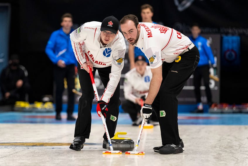 Canada's Scott Weagle, left, and Adam McEachern sweep a rock thrown by Joel Krats at the world junior curling championships in Jonkoping Sweden. The Canadian representatives, out of the Halifax Curling Club and skipped by Owen Purcell, are 3-3. - Cheyenne Boone/ WCF
