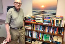 Ron MacDonald stands near the communal library he started at the seniors enriched housing apartments in North Sydney. NICOLE SULLIVAN/CAPE BRETON POST