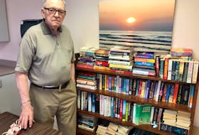 Ron MacDonald stands near the communal library he started at the seniors enriched housing apartments in North Sydney. NICOLE SULLIVAN/CAPE BRETON POST