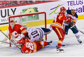 Calgary Flames Elias Lindholm and Edmonton Oilers Derek Ryan crash into each other in front of Calgary Flames goalkeeper Jacob Markstrom during the third period of the first game of the second round of playoff action at Scotiabank Saddledome on Wednesday, May 18, 2022. Flames win 9-6. 