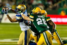 Edmonton Elks safety Jordan Hoover (28) reaches for Winnipeg Blue Bombers receiver Kenny Lawler (89) as he catches the ball at Commonwealth Stadium in Edmonton on Oct. 15, 2021.
