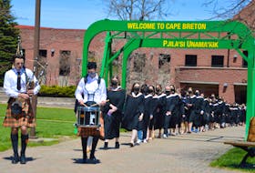 Members of Cape Breton University’s latest graduating class are led by a pipe and drummer as they march to receive their degrees, diplomas and certificates from  CBU on Thursday — the first in-person spring convocation since the COVID-19 pandemic began. Another 500 students from the Shannon School of Business will graduate Friday. Chris Connors/Cape Breton Post