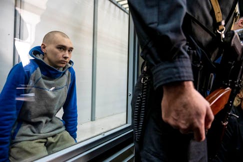 FILE PHOTO: Russian soldier Vadim Shishimarin, 21, suspected of violations of the laws and norms of war, sits inside a defendants' cage during a court hearing, amid Russia's invasion of Ukraine, in Kyiv, Ukraine May 13, 2022. REUTERS/Viacheslav Ratynskyi  Russian soldier Vadim Shishimarin, 21, sits inside a defendants’ cage during a court hearing in Kyiv, Ukraine May 13, 2022. REUTERS/Viacheslav Ratynskyi
