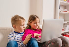 Little girl and boy sitting on sofa with a laptop computer at home. Happy children playing indoors using PC.  Technology is both a blessing and a curse. After 31 years of teaching, retired teacher Natalie Roginsky Edgar has seen the educational pendulum swing in many ways.