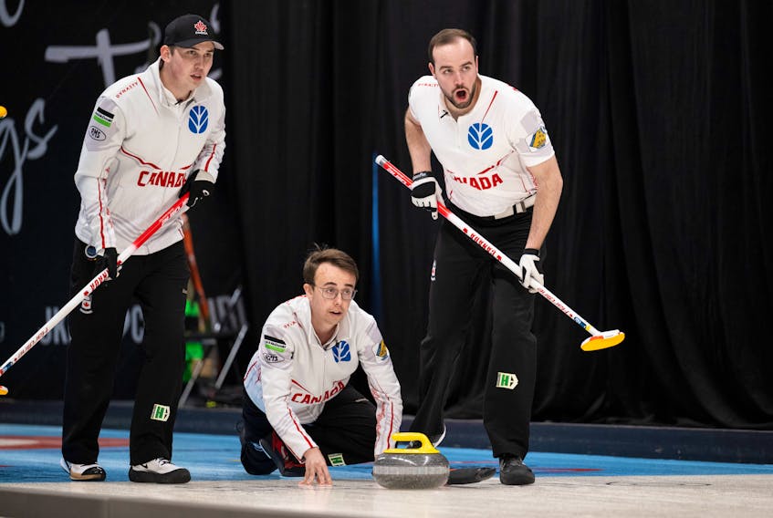 Canadian skip Owen Purcell, middle, releases a rock as lead Scott Weagle, left, and second Adam McEachren prepare to sweep at the world junior curling championships in Jonkoping, Swede. The Canadian rink  advanced to Saturday's semifinal against Germany. - Cheyenne Boone, WCF