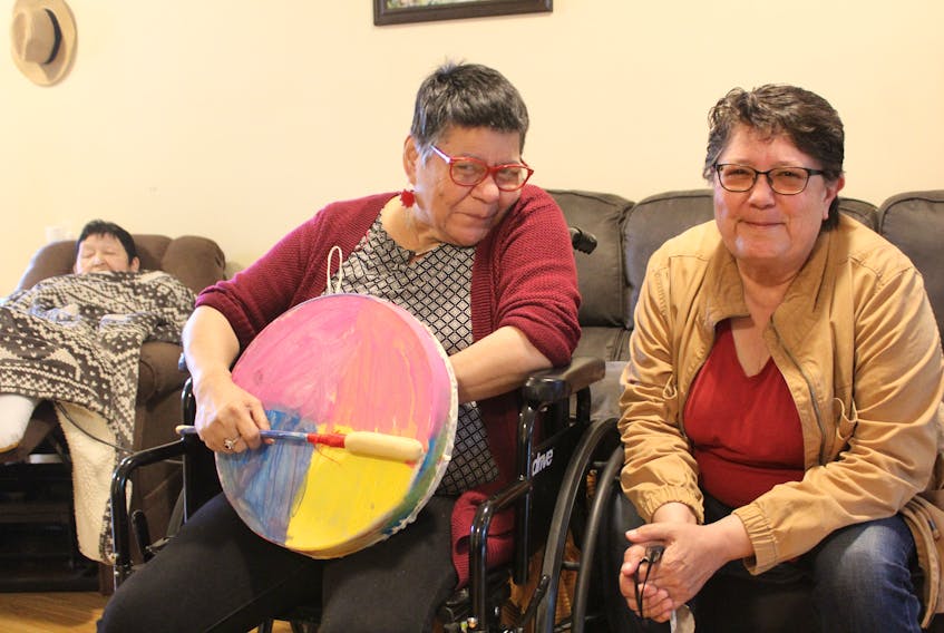 Rosie Sylliboy, right, the manager at Mawita'mk in We'koqma'q, shown with residents of the community home for L'nuk with disabilities, from left, Anna Farrell and Annie Michael, who made and painted the drum she is holding as part of the programming at Mawita'mk. Ardelle Reynolds/Cape Breton Post