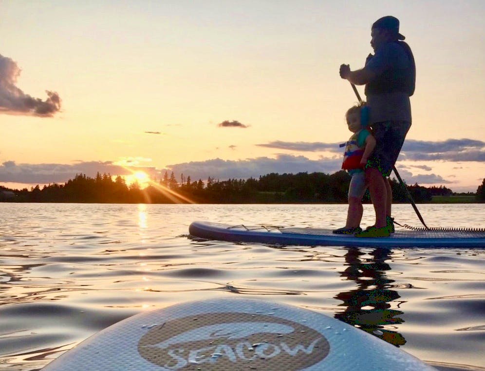 James Shea and his daughter, Abigail, sail into the sunset at Mill River on an inflatable paddleboard. In Shea's opinion, paddleboarding is easy to get the hang of and says he has gotten his friends and family into the sport.