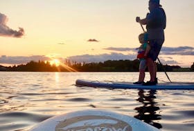 James Shea and his daughter, Abigail, sail into the sunset at Mill River on an inflatable paddleboard. In Shea's opinion, paddleboarding is easy to get the hang of and says he has gotten his friends and family into the sport.