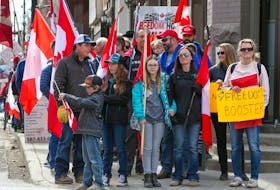 FILE PHOTO: Anti-mandate protesters wait at a light while walking to Calgary City Hall on Saturday, March 19, 2022. The protesters met in Central Memorial Park and then walked on the sidewalks to City Hall.