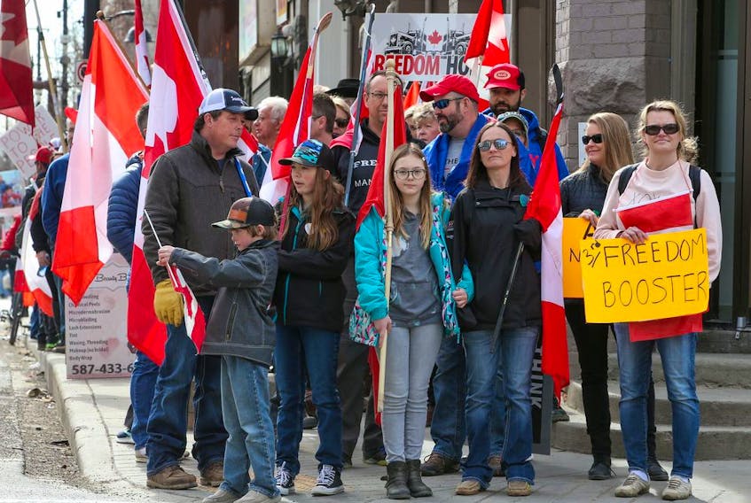 FILE PHOTO: Anti-mandate protesters wait at a light while walking to Calgary City Hall on Saturday, March 19, 2022. The protesters met in Central Memorial Park and then walked on the sidewalks to City Hall.