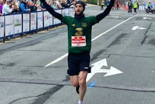 Nathan Ryan O Hehir, who's originally from Cork, Ireland, crosses the finish line first in the men's full marathon at the Blue Nose Marathon in Halifax on Sunday. He posted a personal-best time of 2:42:27. - GLENN MacDONALD / THE CHRONICLE HERALD