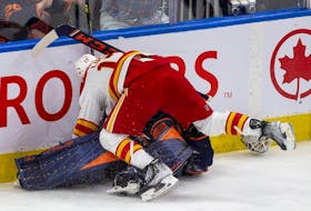 Edmonton Oilers goaltender Mike Smith (41) is pushed over by Calgary Flames Milan Lucic (17) during third period NHL second round playoff hockey action on Sunday, May 22, 2022 in Edmonton. 