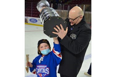 Summerside D. Alex MacDonald Ford Western Capitals assistant coach Tim Schurman and his five-year-old daughter, Ruby, lift the Canadian Tire Cup after the Caps won the Maritime Junior Hockey League (MHL) championship on May 2.