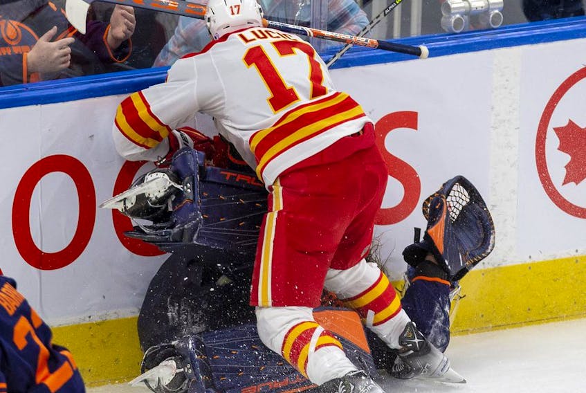 Edmonton Oilers goaltender Mike Smith (41) is hit by Calgary Flames Milan Lucic (17) during third period NHL second round playoff hockey action on Sunday, May 22, 2022.