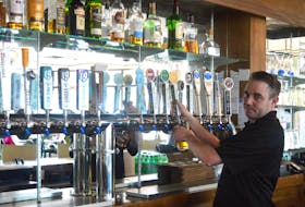 Jordan Hynes, bar manager for the Boardwalk Taproom and Eatery, serves up a beverage at the Sydney waterfront restaurant owned by Danny Ellis. Finding labour to work at food and beverage establishments ahead of the tourist season continues to be a struggle, Ellis says. IAN NATHANSON/CAPE BRETON POST