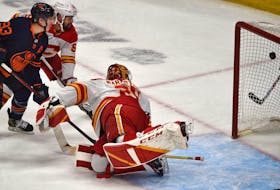 Edmonton Oilers forward Ryan Nugent-Hopkins scores the eventual game-winner on Calgary Flames goalie Jacob Markstrom while battling defenceman Oliver Kylington during Game 4 of their second-round playoff series 
at Rogers Place in Edmonton on Tuesday, May 24, 2022.